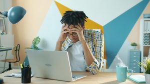 frustrated person with computer due to site blocking laws and streaming issues